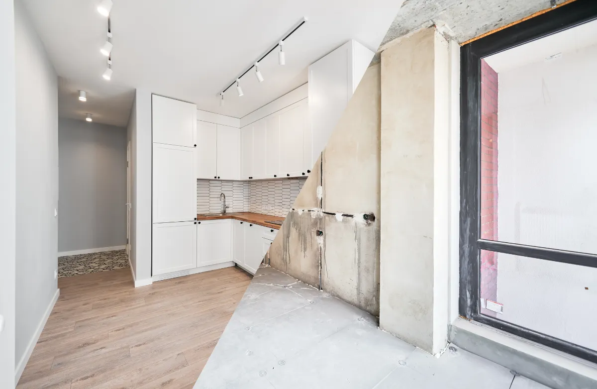 Apartment kitchen shown half before and half after renovation